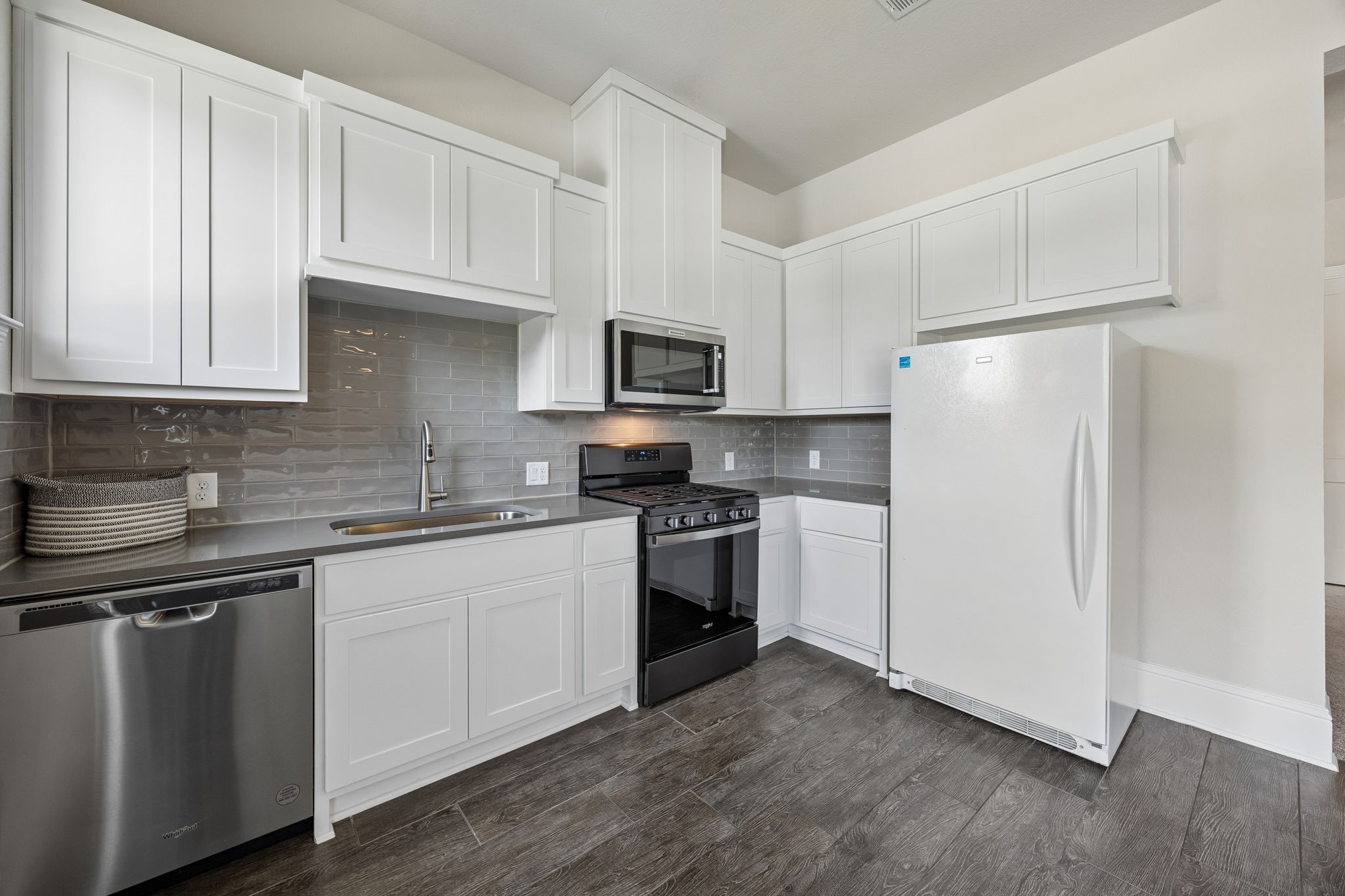 10102 South Goshawk Trail Conroe, TX 77385 - Photo 26 of 46 a kitchen with cabinets stainless steel appliances and a wooden floor
