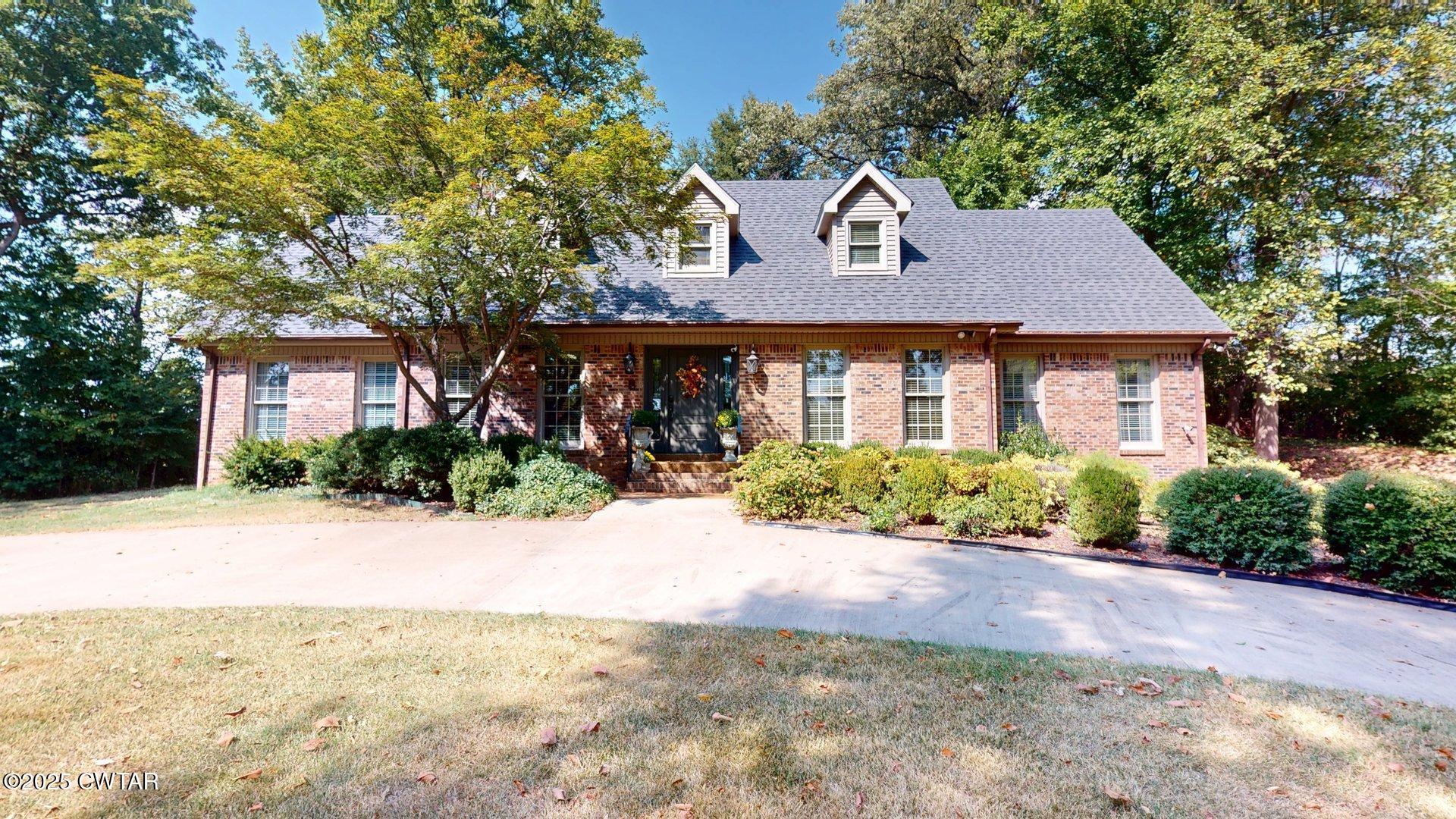 a front view of a house with a yard and potted plants