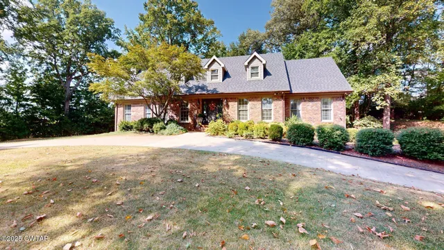 a front view of a house with a yard and potted plants