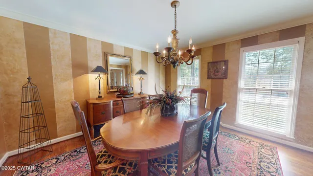 a dining room with furniture a chandelier and wooden floor