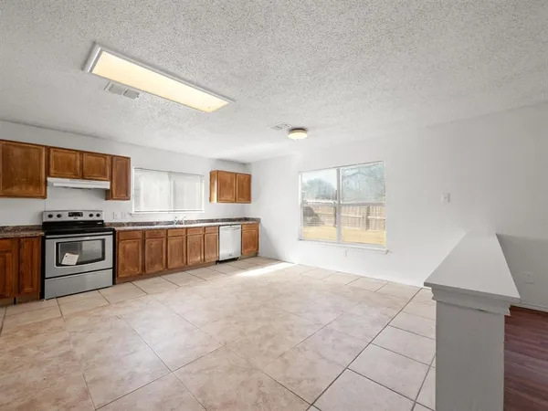 a large kitchen with a stove and a refrigerator