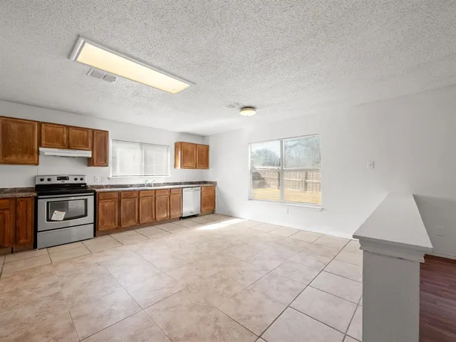 a large kitchen with a stove and a refrigerator
