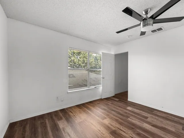 a view of a big room with wooden floor and windows