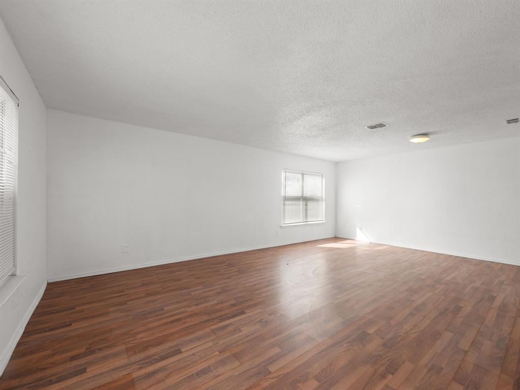 1237 McCary Street Cedar Hill, TX 75104 - Photo 5 of 38 a view of an empty room with wooden floor and window