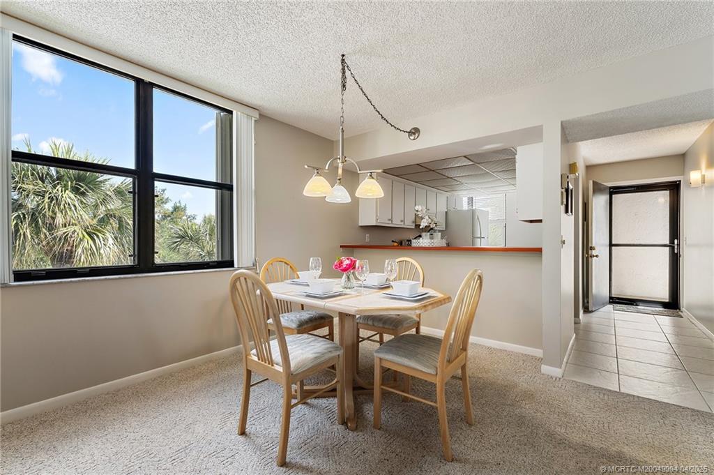 1950 Southwest Palm City Road, Unit 5310 Stuart, FL 34994 - Photo 21 of 72 a view of a dining room with furniture window and wooden floor