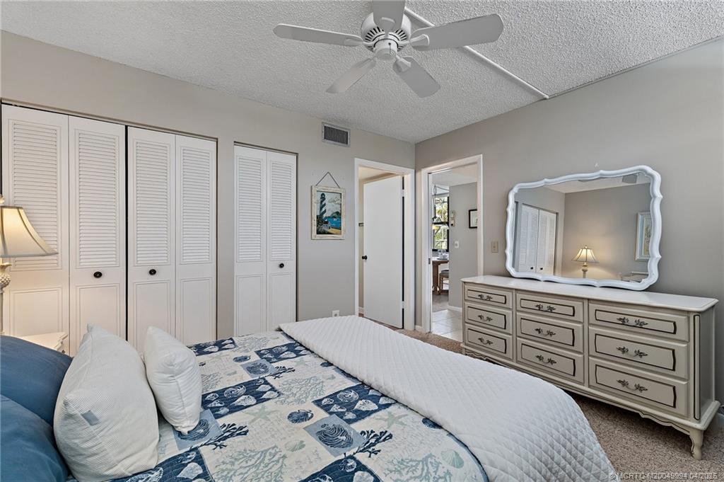 1950 Southwest Palm City Road, Unit 5310 Stuart, FL 34994 - Photo 22 of 72 a bedroom with a bed a chandelier and dresser