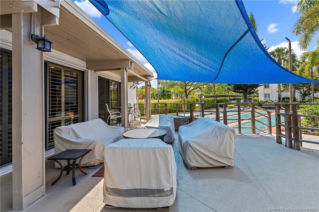 1950 Southwest Palm City Road, Unit 5310 Stuart, FL 34994 - Photo 54 of 72 a view of a patio with table and chairs under an umbrella