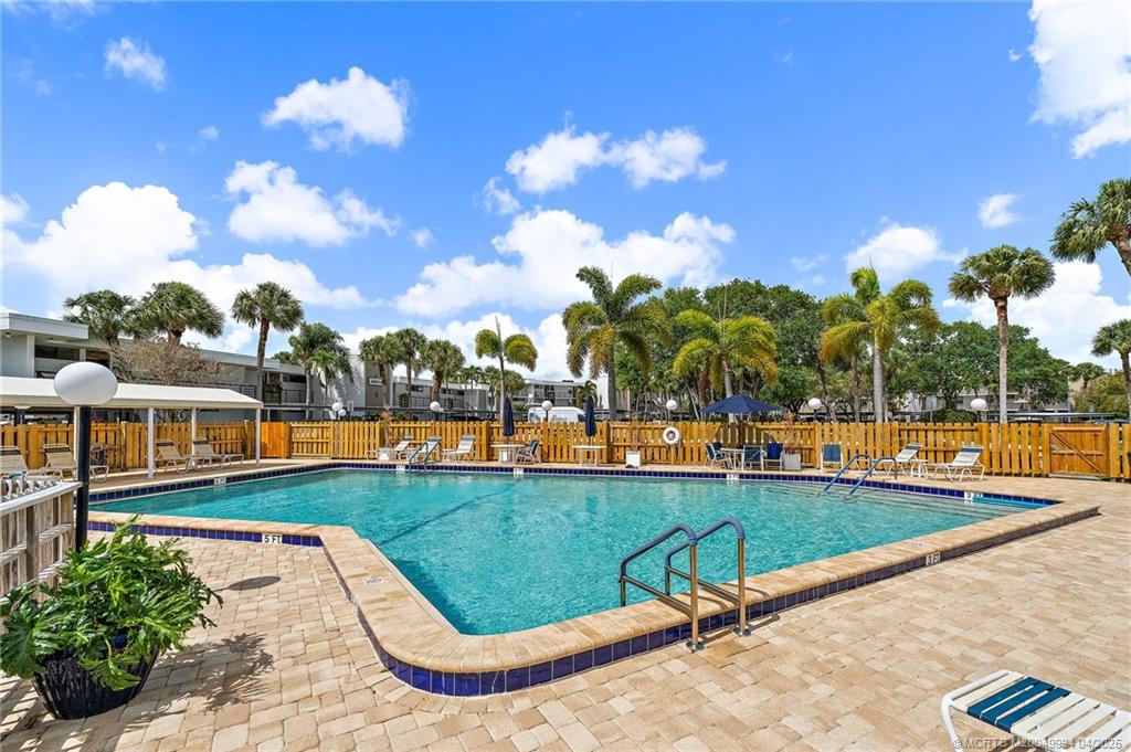 1950 Southwest Palm City Road, Unit 5310 Stuart, FL 34994 - Photo 9 of 72 a swimming pool with outdoor seating and yard