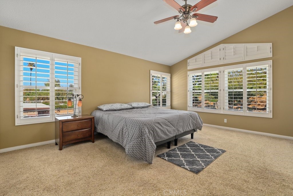 7910 Westgate Court Riverside, CA 92506 - Photo 24 of 61 a spacious bedroom with a bed and a chandelier