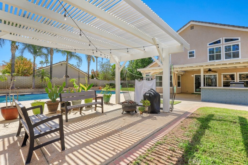 7910 Westgate Court Riverside, CA 92506 - Photo 39 of 61 a view of a patio with table and chairs potted plants with wooden floor and fence