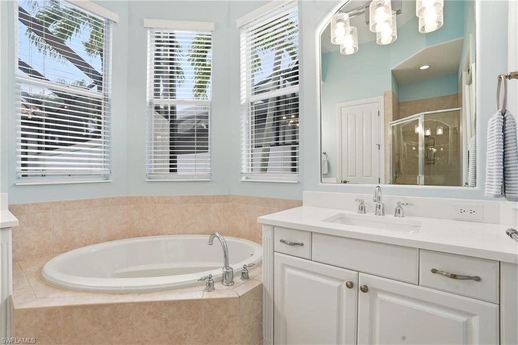 7840 Valencia Court Naples, FL 34113 - Photo 13 of 24 Bathroom with vanity, a shower stall, and a bath