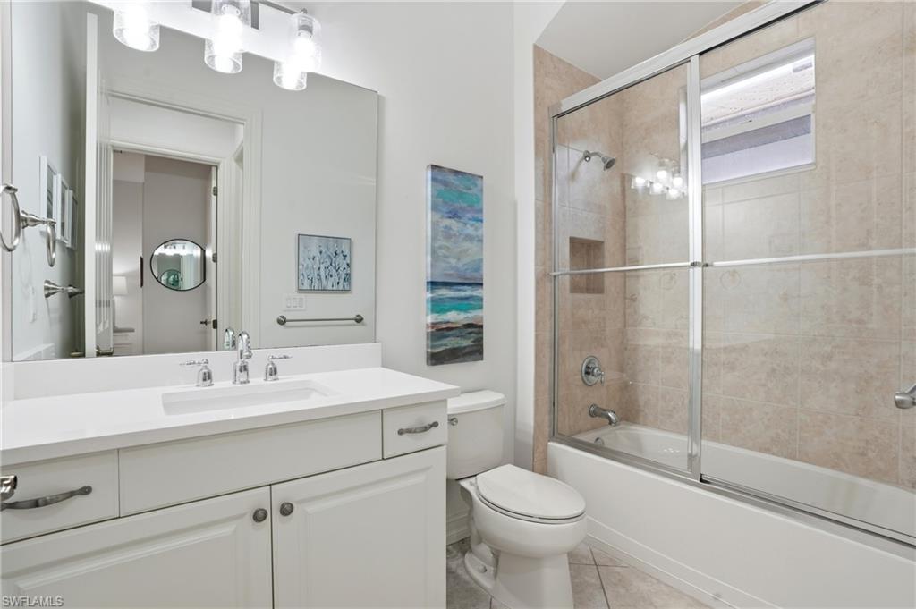 7840 Valencia Court Naples, FL 34113 - Photo 17 of 24 Full bathroom with shower / bath combination with glass door, vanity, and light tile patterned floors