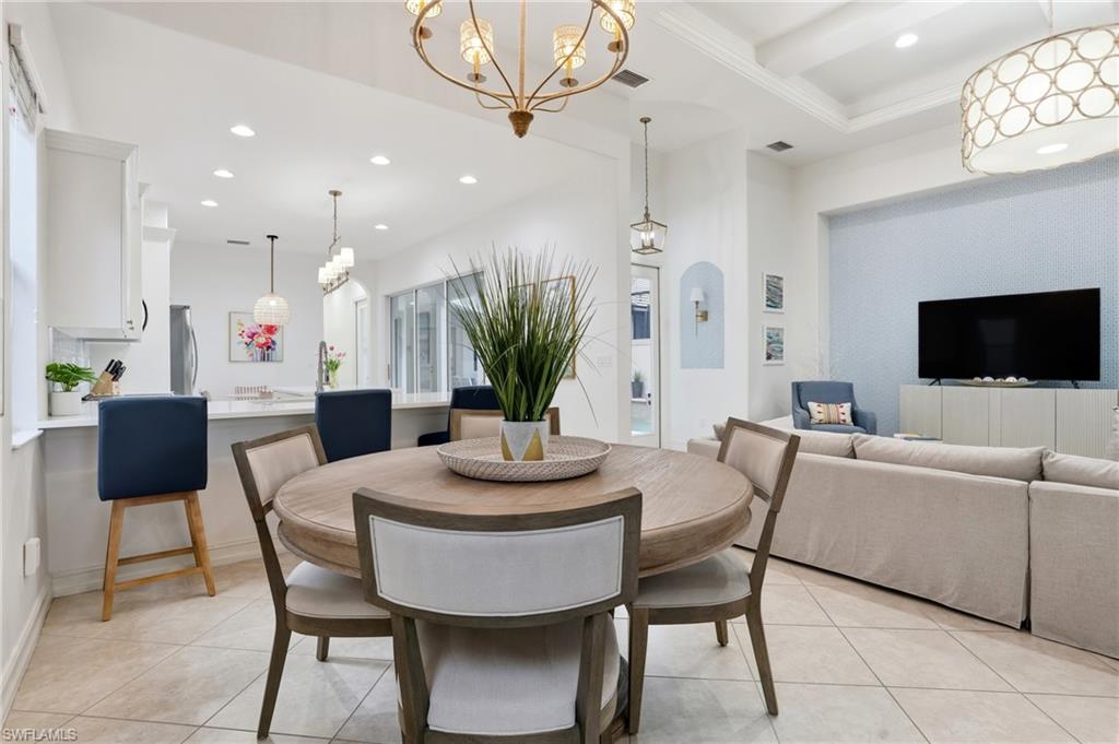7840 Valencia Court Naples, FL 34113 - Photo 4 of 24 Dining space featuring light tile patterned floors, recessed lighting, and a chandelier