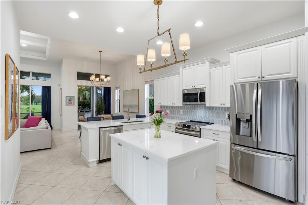 7840 Valencia Court Naples, FL 34113 - Photo 8 of 24 Kitchen featuring stainless steel appliances, tasteful backsplash, white cabinetry, light tile patterned flooring, and recessed lighting