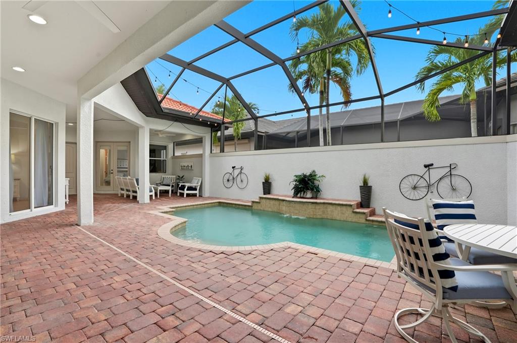 7840 Valencia Court Naples, FL 34113 - Photo 10 of 24 Swimming pool with a patio area, a lanai, a sunroom, outdoor dining area, and a ceiling fan