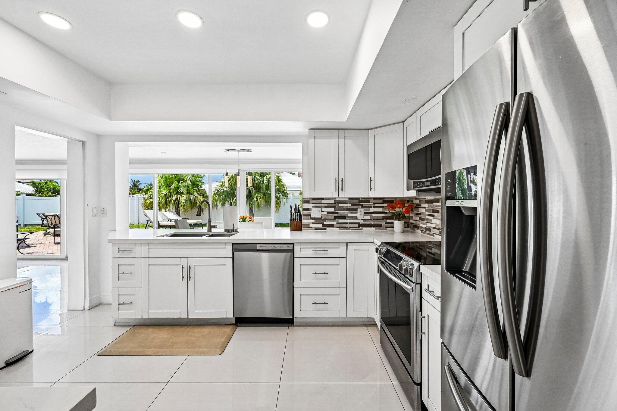 2940 Northeast 39th Court Lighthouse Point, FL 33064 - Photo 10 of 42 a kitchen with stainless steel appliances granite countertop a refrigerator sink and stove