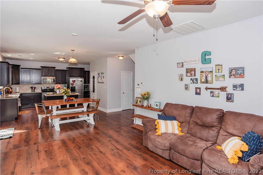 461 St Johns Loop Raeford, NC 28376 - Photo 18 of 50 a living room with furniture kitchen view and a wooden floor