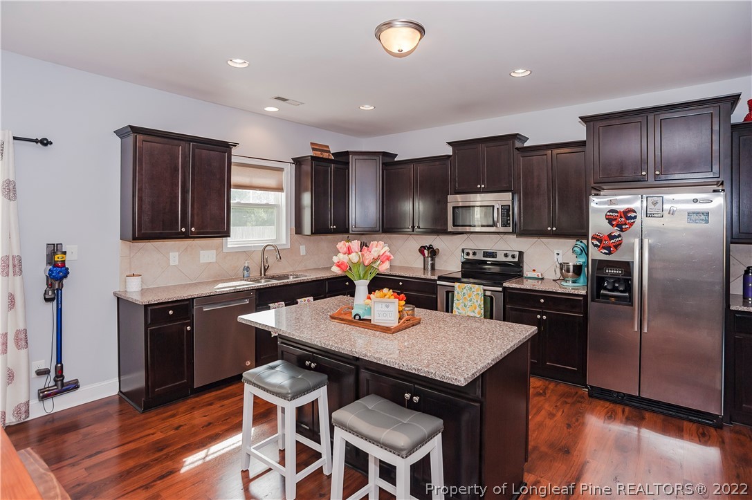 461 St Johns Loop Raeford, NC 28376 - Photo 21 of 50 a kitchen with granite countertop stainless steel appliances and wooden cabinets