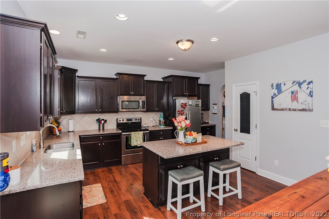 461 St Johns Loop Raeford, NC 28376 - Photo 23 of 50 a kitchen with kitchen island granite countertop a sink appliances and cabinets