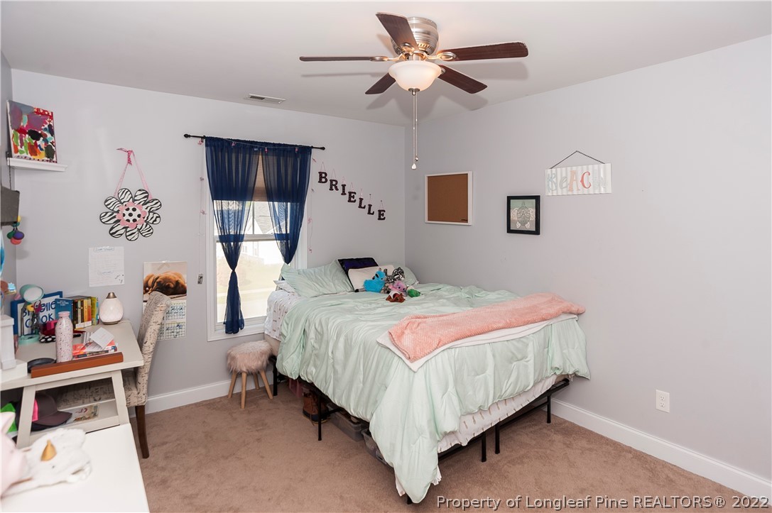 461 St Johns Loop Raeford, NC 28376 - Photo 49 of 50 a bedroom with a bed and a chandelier