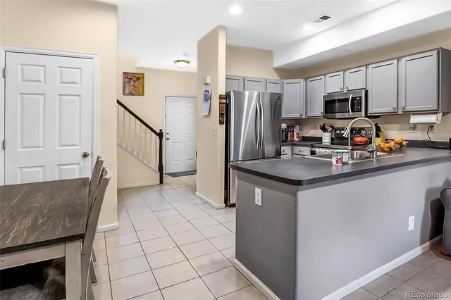 a kitchen with stainless steel appliances granite countertop a refrigerator stove microwave and sink