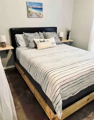 a bedroom with a bed and painting on the wall