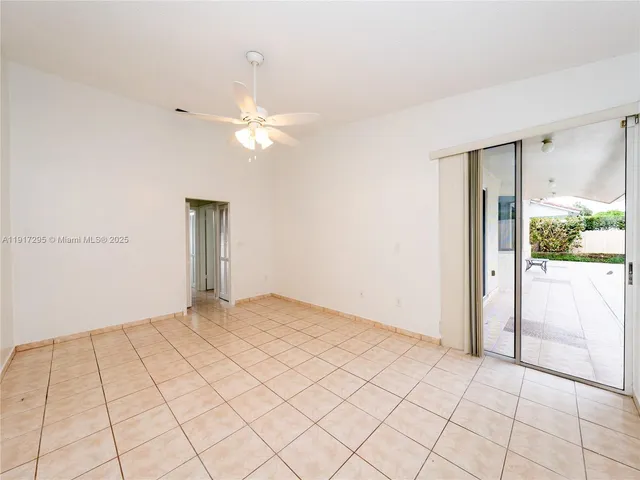 an empty room with fan and a chandelier fan