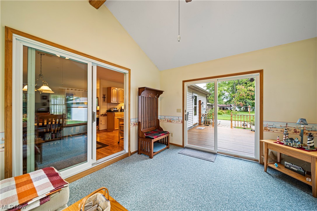 431 Ansel Road Geneva, OH 44041 - Photo 23 of 35 Doorway featuring light carpet, vaulted ceiling, and a high ceiling