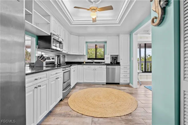 a kitchen with stainless steel appliances kitchen island granite countertop a stove a sink and a microwave