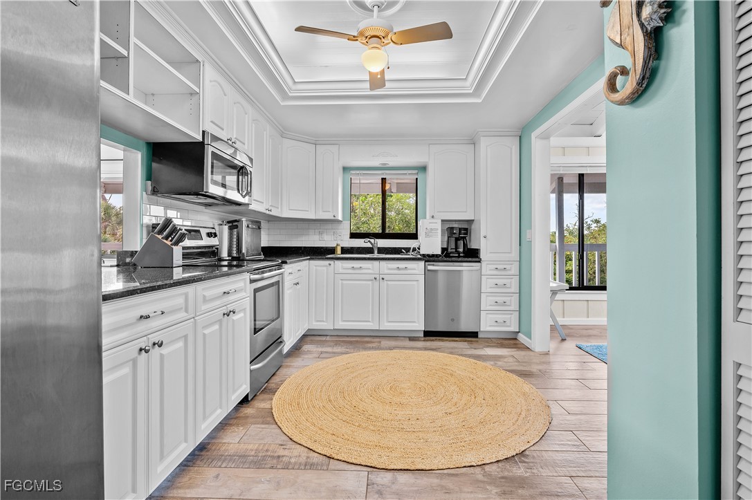 14171 Bokeelia Road Bokeelia, FL 33922 - Photo 9 of 25 a kitchen with stainless steel appliances kitchen island granite countertop a stove a sink and a microwave