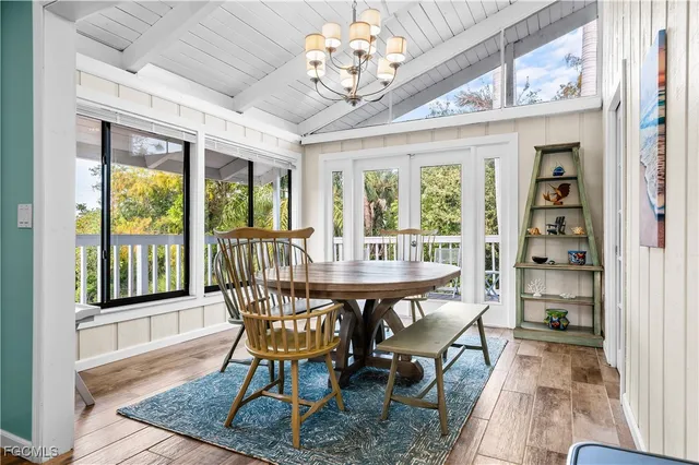 a dining room with furniture a chandelier and wooden floor