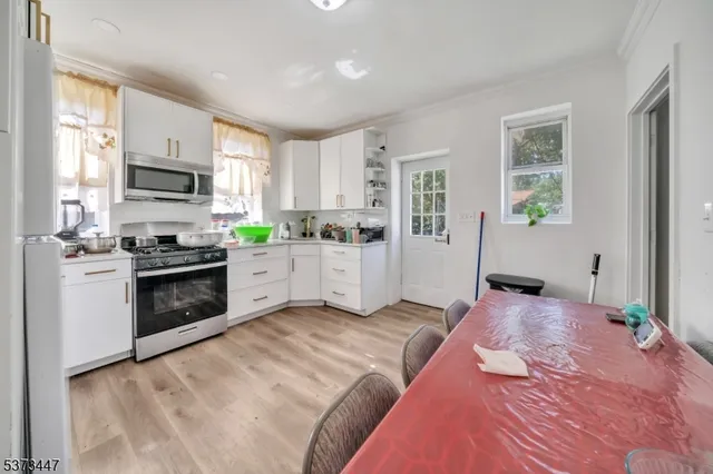 a kitchen with granite countertop a stove top oven a sink a dining table and chairs