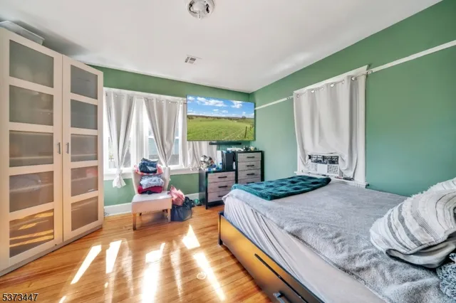 a bedroom with a bed and large windows