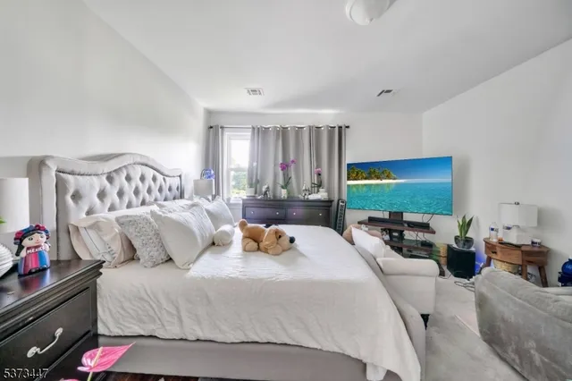 a bedroom with furniture and a flat screen tv