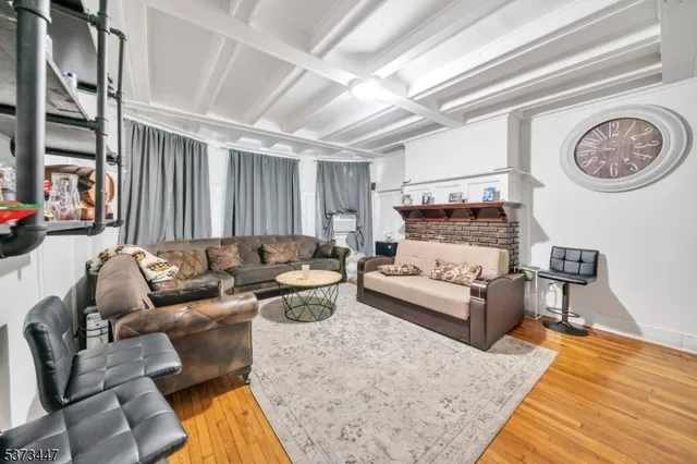 a living room with furniture a clock on wall and a window