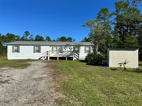 a view of a house with a yard and sitting area