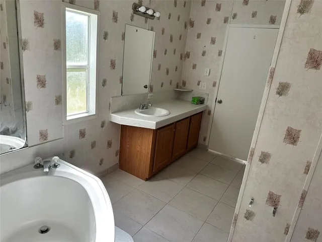 a bathroom with a tub sink and mirror