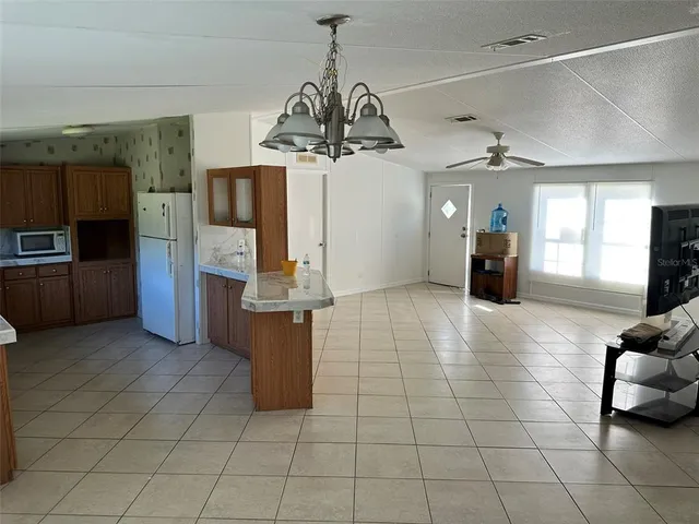 a view of a kitchen with furniture and stainless steel appliances
