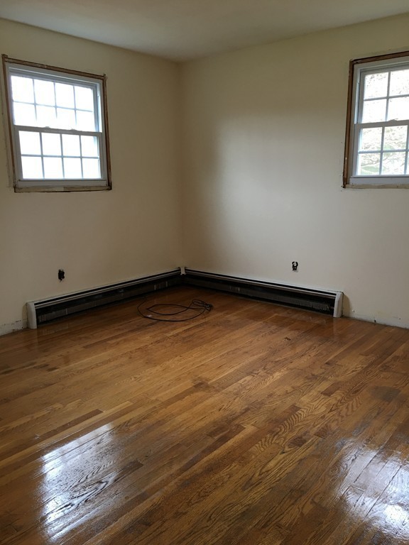 12 Mill Road Chelmsford, MA 01824 - Photo 5 of 11 an empty room with wooden floor and windows