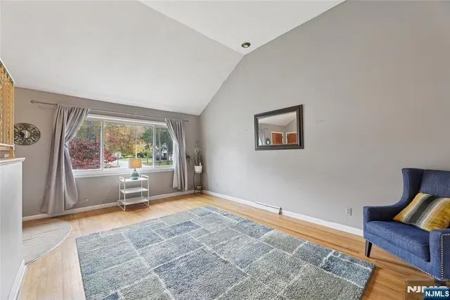 a view of a hallway with wooden floor and dining room