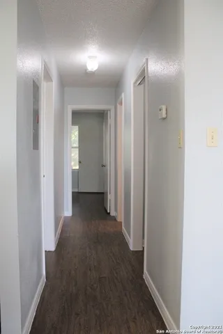 a view of a hallway with wooden floor