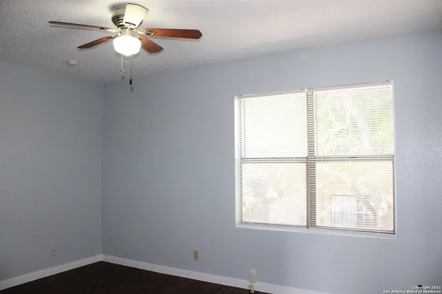 a view of a room with a window and a fan