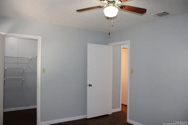 a view of a hallway with a chandelier fan