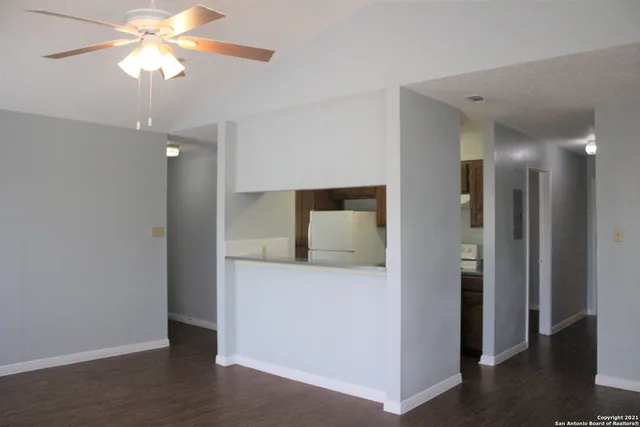a view of a hallway with a chandelier fan and a livingroom