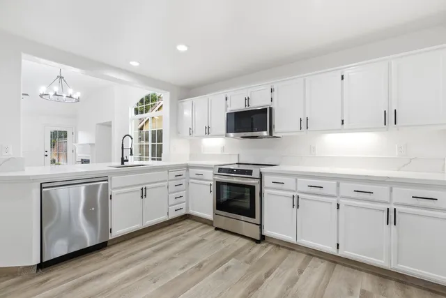 a kitchen with granite countertop white cabinets and white appliances