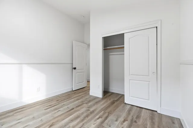 an empty room with wooden floor and closet
