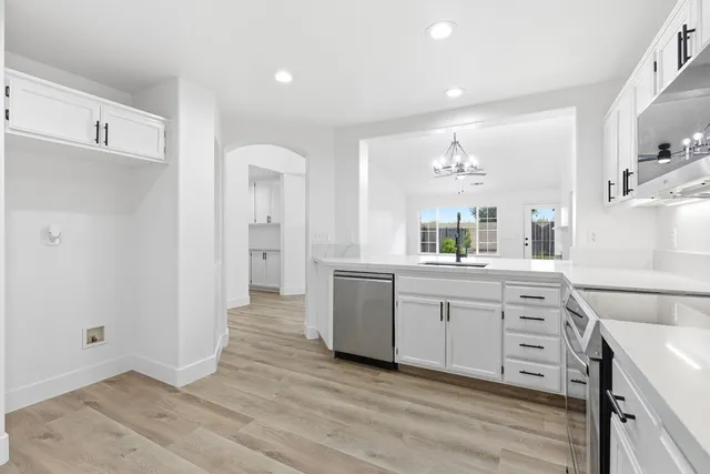 a large kitchen with a lot of counter space and wooden floor
