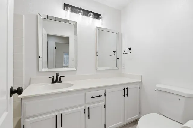 a bathroom with a sink toilet and mirror