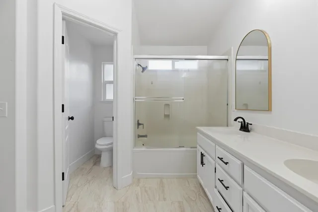 a bathroom with a sink a toilet and shower