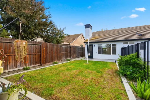 a view of a house with backyard and wooden fence